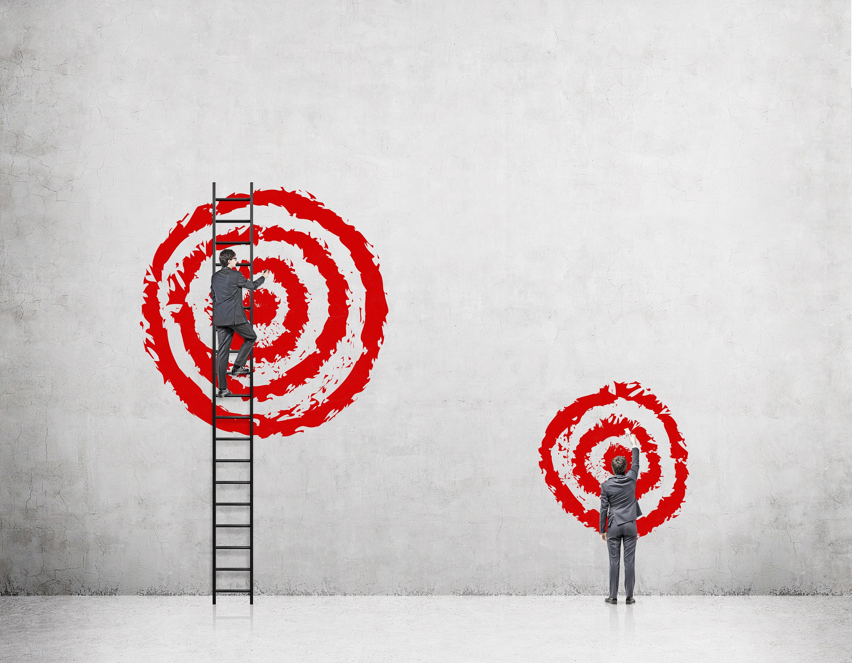 businessman painting big red circles as target while standing on ladder,  setting big goals